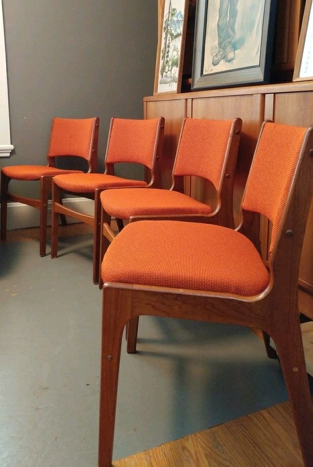 set of 4 Teak framed dining chairs with orange upholstered seats and backs. Vintage teak dining chairs for sale.