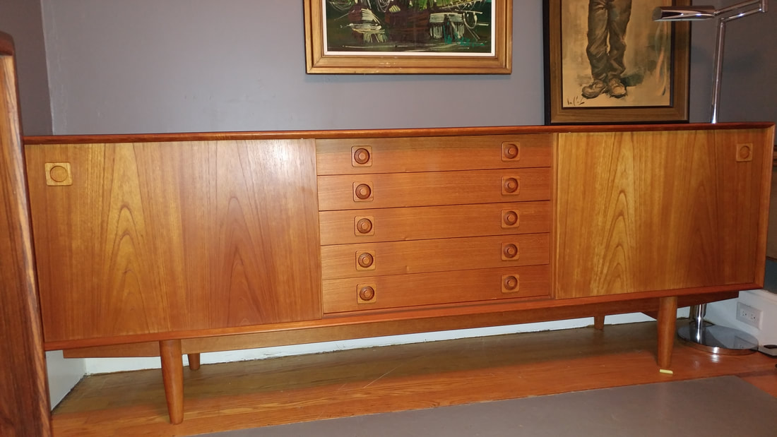 1960's large teak buffet for sale with 2 sliding doors and 5 drawers in the middle. Sliding doors with adjustable shelving